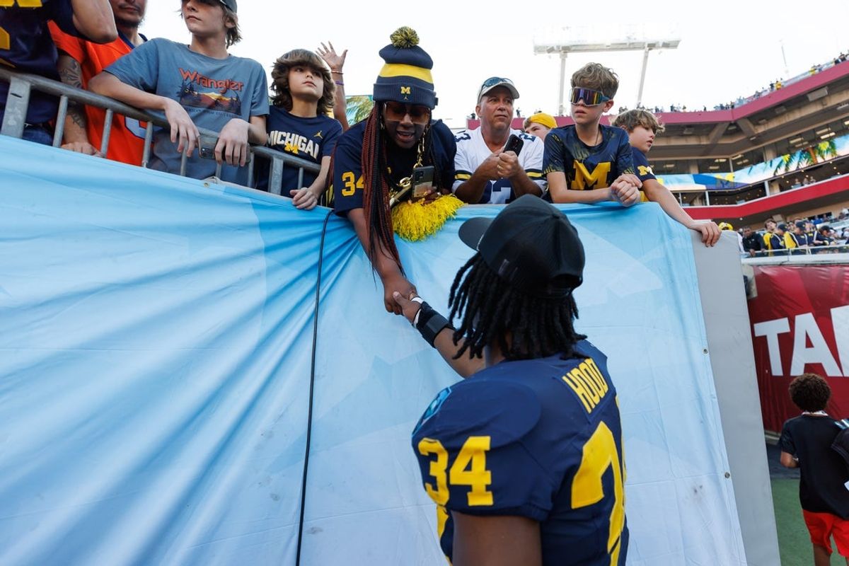 Dec 31, 2024; Tampa, FL, USA; Michigan Wolverines linebacker Jaydon Hood (34) talks with his mother after a game against the Alabama Crimson Tide at Raymond James Stadium. Mandatory Credit: Matt Pendleton-Imagn Images