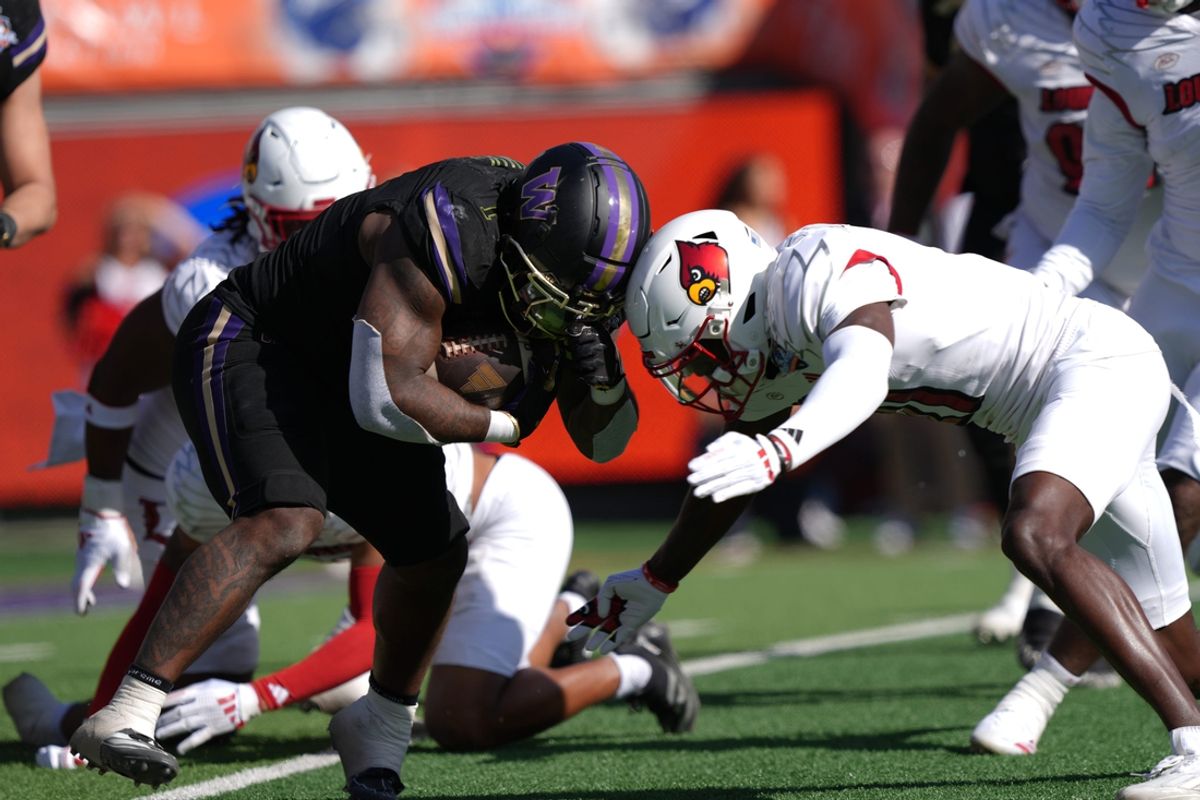 Washington player Jonah Coleman (1) runs for yardage against Louisville during the Tony the Tiger Sun Bowl game on Dec. 31, 2024.