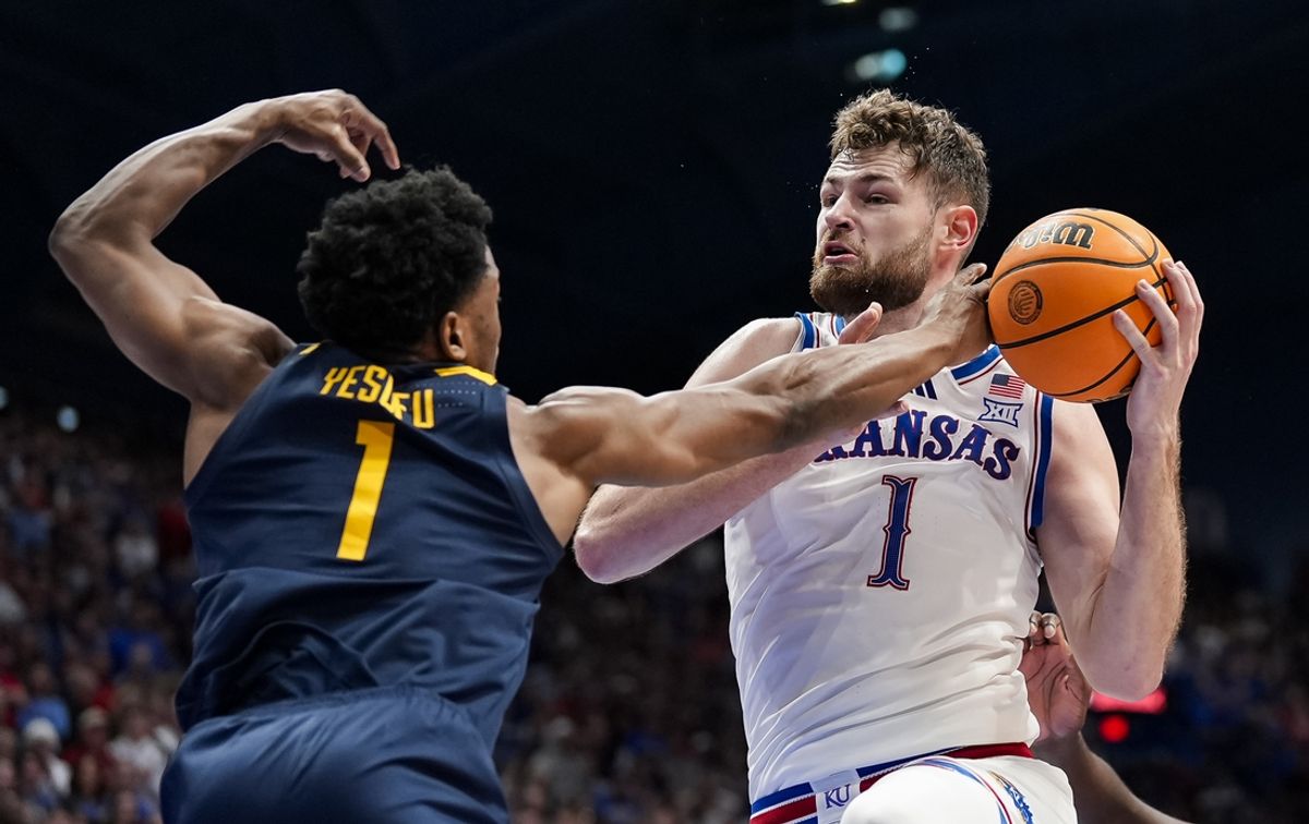 Dec 31, 2024; Lawrence, Kansas, USA; Kansas Jayhawks center Hunter Dickinson (1) and West Virginia Mountaineers guard Joseph Yesufu (1) fight for a rebound during the second half at Allen Fieldhouse. Mandatory Credit: Jay Biggerstaff-Imagn Images