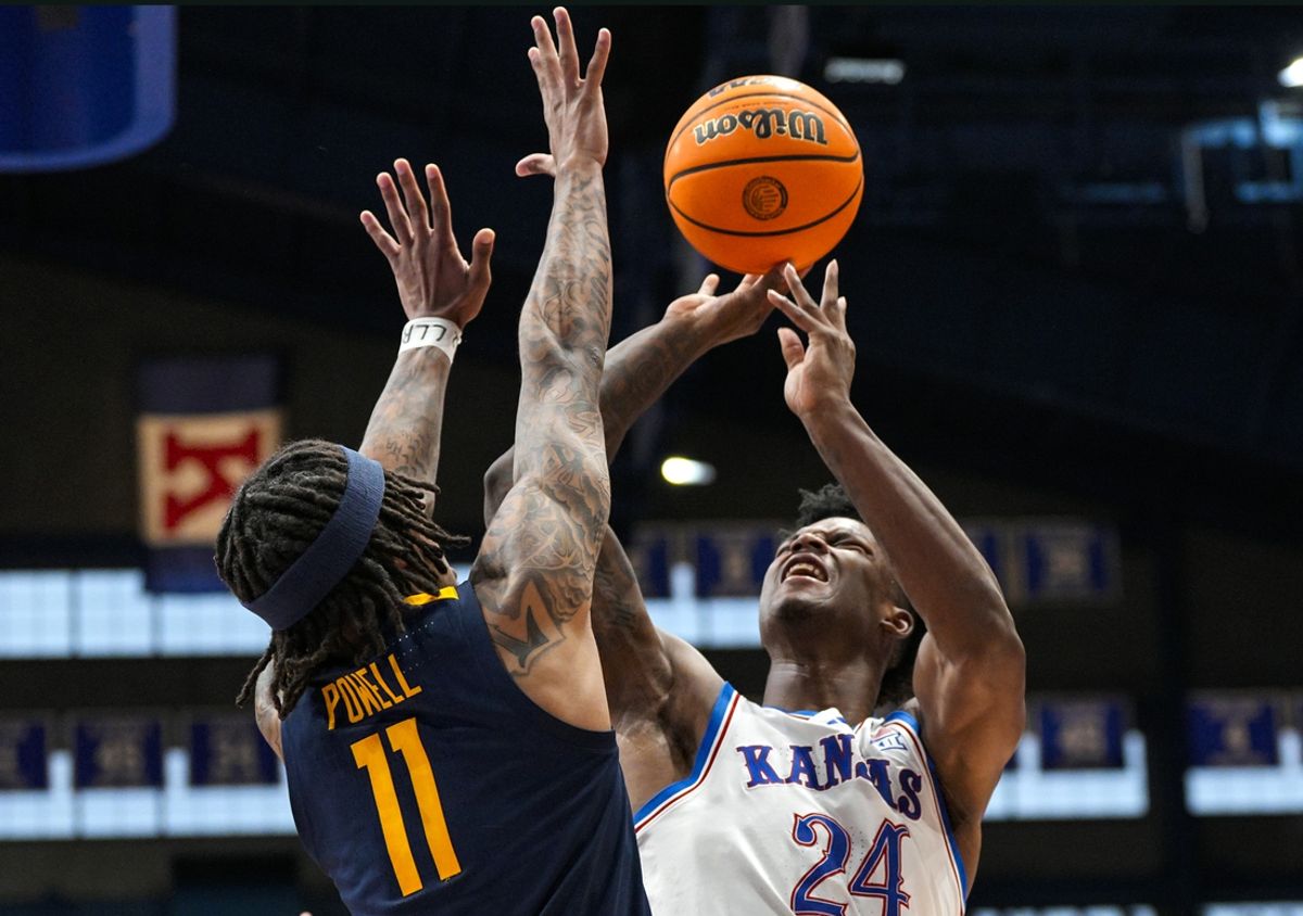 Dec 31, 2024; Lawrence, Kansas, USA; Kansas Jayhawks forward KJ Adams Jr. (24) shoots against West Virginia Mountaineers guard Jonathan Powell (11) as time expires in the second half at Allen Fieldhouse. Mandatory Credit: Jay Biggerstaff-Imagn Images