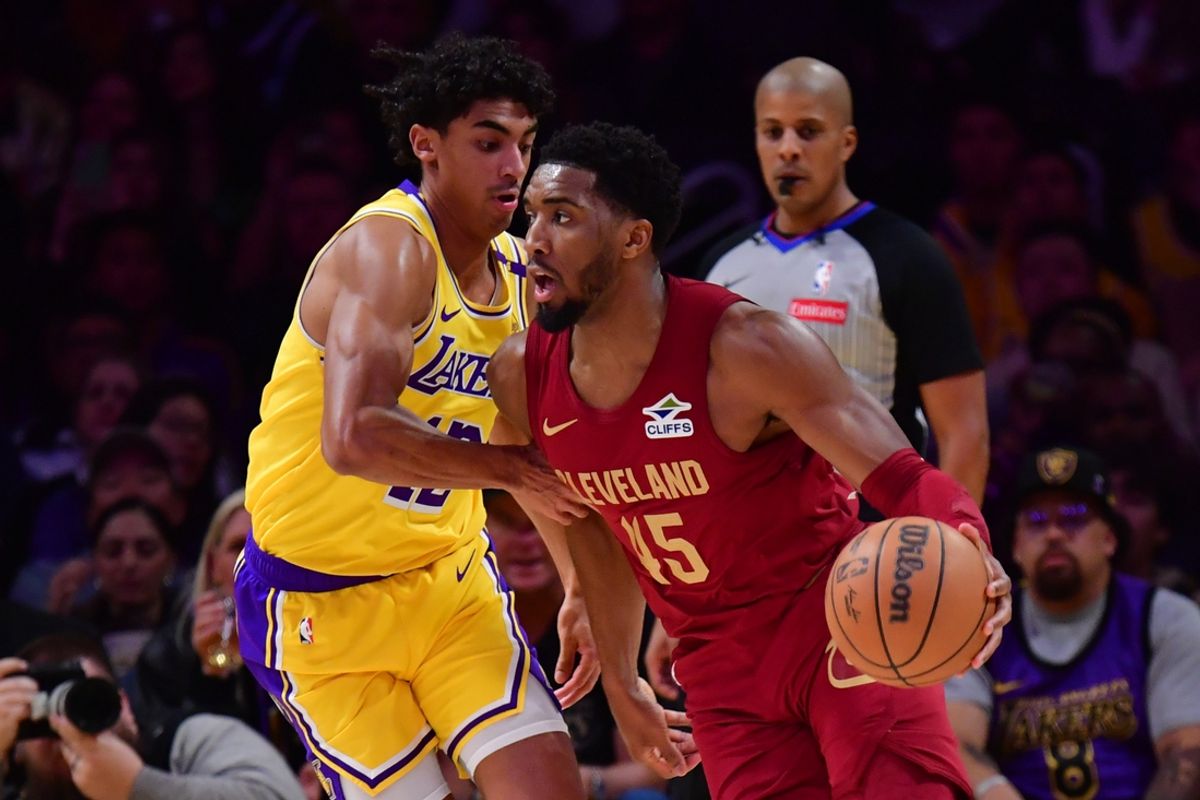 Dec 31, 2024; Los Angeles, California, USA;  Cleveland Cavaliers guard Donovan Mitchell (45) moves the ball against Los Angeles Lakers guard Max Christie (12) during the first half at Crypto.com Arena. Mandatory Credit: Gary A. Vasquez-Imagn Images
