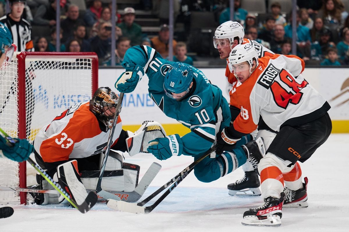 Dec 31, 2024; San Jose, California, USA; San Jose Sharks center Klim Kostin (10) is checked by Philadelphia Flyers center Morgan Frost (48) and defenseman Nick Seeler (24) as goaltender Samuel Ersson (33) protects the net during the second period at SAP Center at San Jose. Mandatory Credit: Robert Edwards-Imagn Images