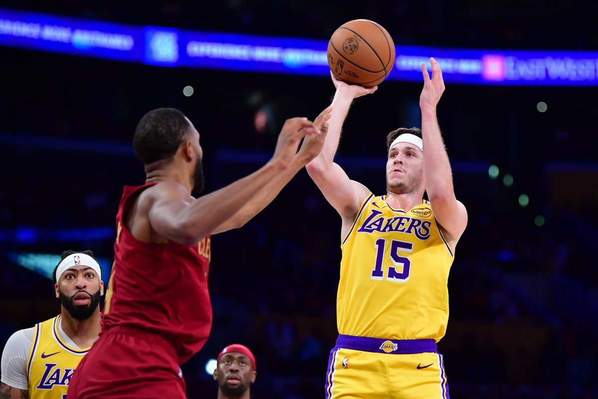 Dec 31, 2024; Los Angeles, California, USA; Los Angeles Lakers guard Austin Reaves (15) shoots against Cleveland Cavaliers forward Evan Mobley (4) during the first half at Crypto.com Arena. Mandatory Credit: Gary A. Vasquez-Imagn Images