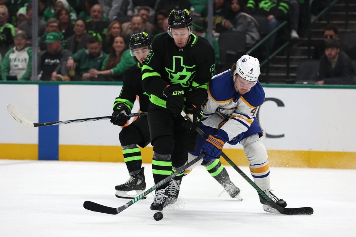 Dec 31, 2024; Dallas, Texas, USA; Dallas Stars right wing Evgenii Dadonov (63) fights for the puck against Buffalo Sabres defenseman Bowen Byram (4) during the third period at American Airlines Center. Mandatory Credit: Tim Heitman-Imagn Images
