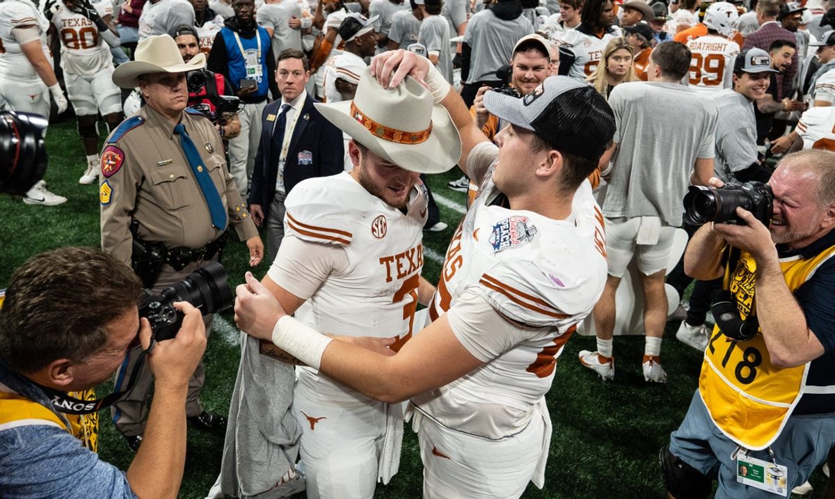 Texas Longhorns tight end Gunnar Helm (85) gives Texas Longhorns quarterback Quinn Ewers (3) a hat as they celebrate their win in the Peach Bowl College Football Playoff quarterfinal against Arizona State at Mercedes-Benz Stadium in Atlanta, Georgia, Jan. 1, 2025.