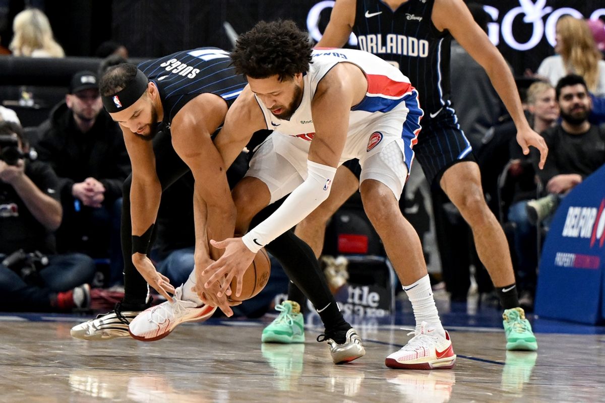 Jan 1, 2025; Detroit, Michigan, USA; Orlando Magic guard Jalen Suggs (4) and Detroit Pistons guard Cade Cunningham (2) battle for a loose ball in the second quarter at Little Caesars Arena. Mandatory Credit: Lon Horwedel-Imagn Images