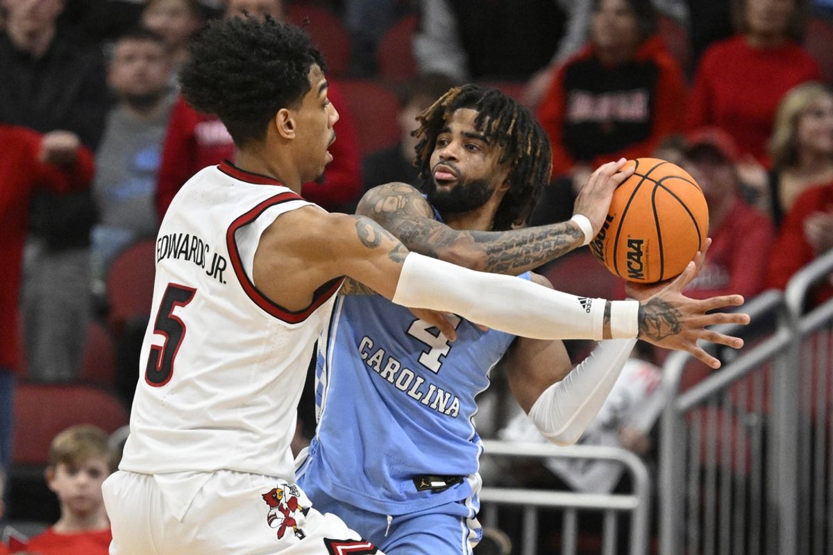 Jan 1, 2025; Louisville, Kentucky, USA;  North Carolina Tar Heels guard RJ Davis (4) looks to pass under the pressure of Louisville Cardinals guard Terrence Edwards Jr. (5) during the second half at KFC Yum! Center. Mandatory Credit: Jamie Rhodes-Imagn Images