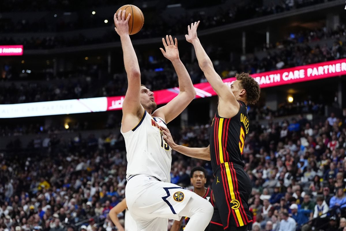 Jan 1, 2025; Denver, Colorado, USA; Atlanta Hawks guard Dyson Daniels (5) defends on Denver Nuggets center Nikola Jokic (15) in the second quarter at Ball Arena. Mandatory Credit: Ron Chenoy-Imagn Images