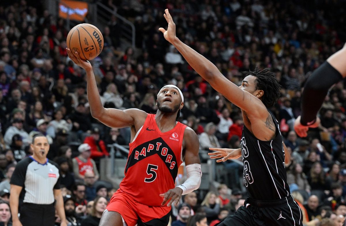 Jan 1, 2025; Toronto, Ontario, CAN;   Toronto Raptors guard Immanuel Quickley (5) drives to the basket past Brooklyn Nets center Nic Claxton (33) in the second half at Scotiabank Arena. Mandatory Credit: Dan Hamilton-Imagn Images