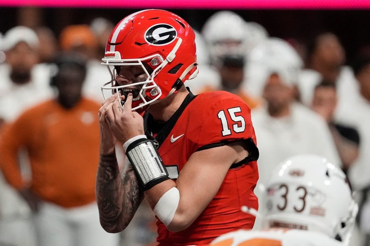 Georgia quarterback Carson Beck puts in his mouth grad on the final play during overtime of the SEC championship game against Texas.