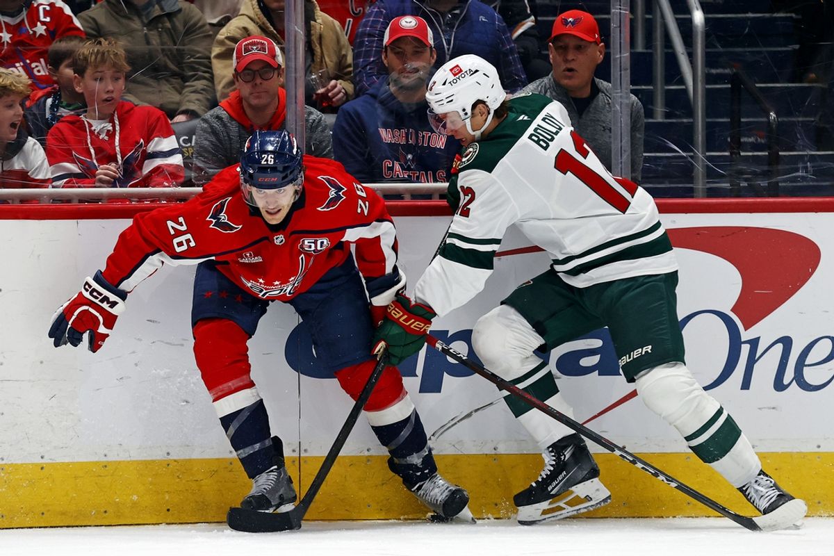 Jan 2, 2025; Washington, District of Columbia, USA; Washington Capitals center Nic Dowd (26) and Minnesota Wild left wing Matt Boldy (12) go for the puck at Capital One Arena. Mandatory Credit: Peter Casey-Imagn Images
