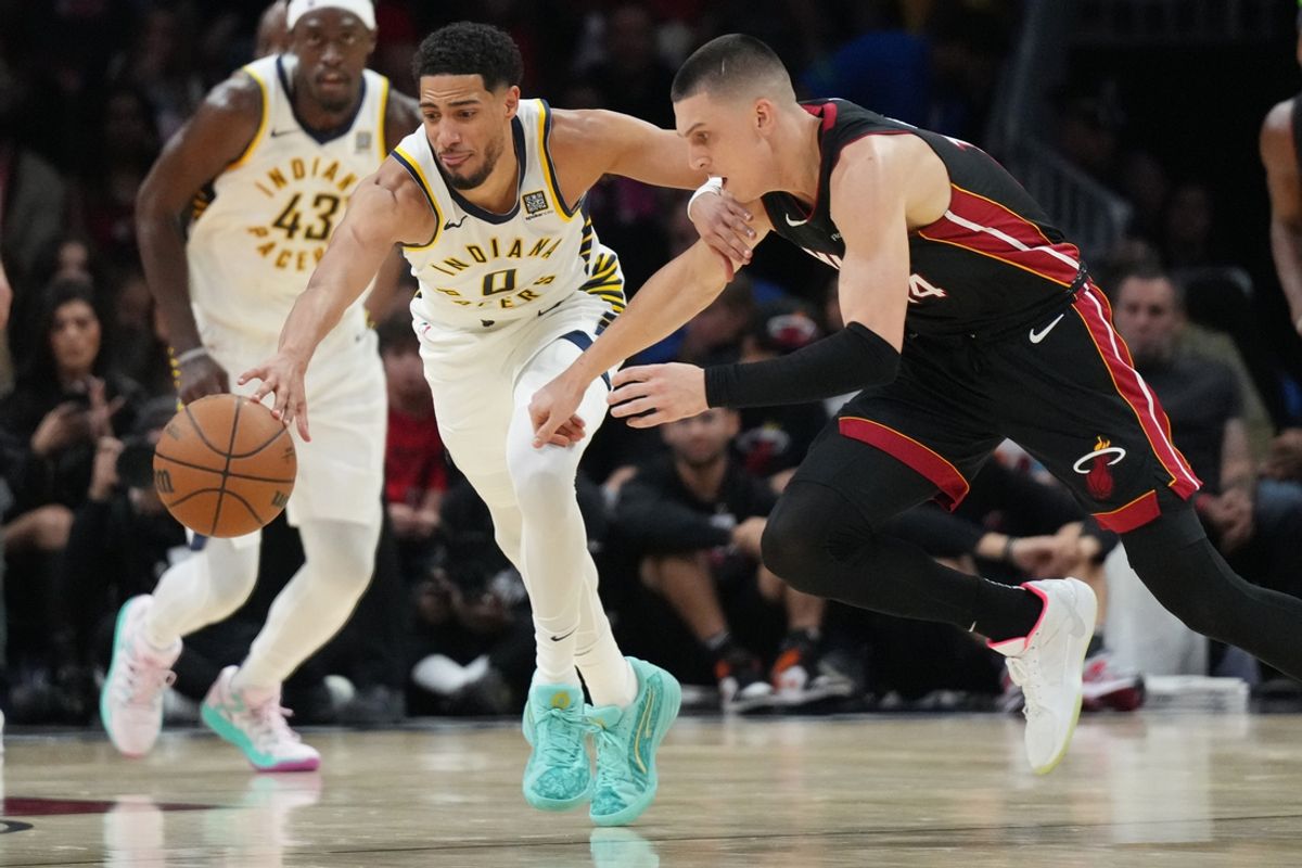 Jan 2, 2025; Miami, Florida, USA;  Indiana Pacers guard Tyrese Haliburton (0) battles for a loose ball with Miami Heat guard Tyler Herro (14) during the first half at Kaseya Center. Mandatory Credit: Jim Rassol-Imagn Images