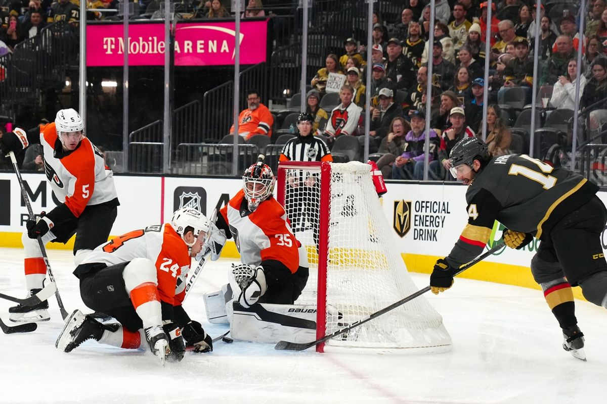 Jan 2, 2025; Las Vegas, Nevada, USA; Vegas Golden Knights defenseman Nicolas Hague (14) banks a shot off the stick of Philadelphia Flyers defenseman Nick Seeler (24) to score a goal against  goaltender Aleksei Kolosov (35) during the second period at T-Mobile Arena. Mandatory Credit: Stephen R. Sylvanie-Imagn Images