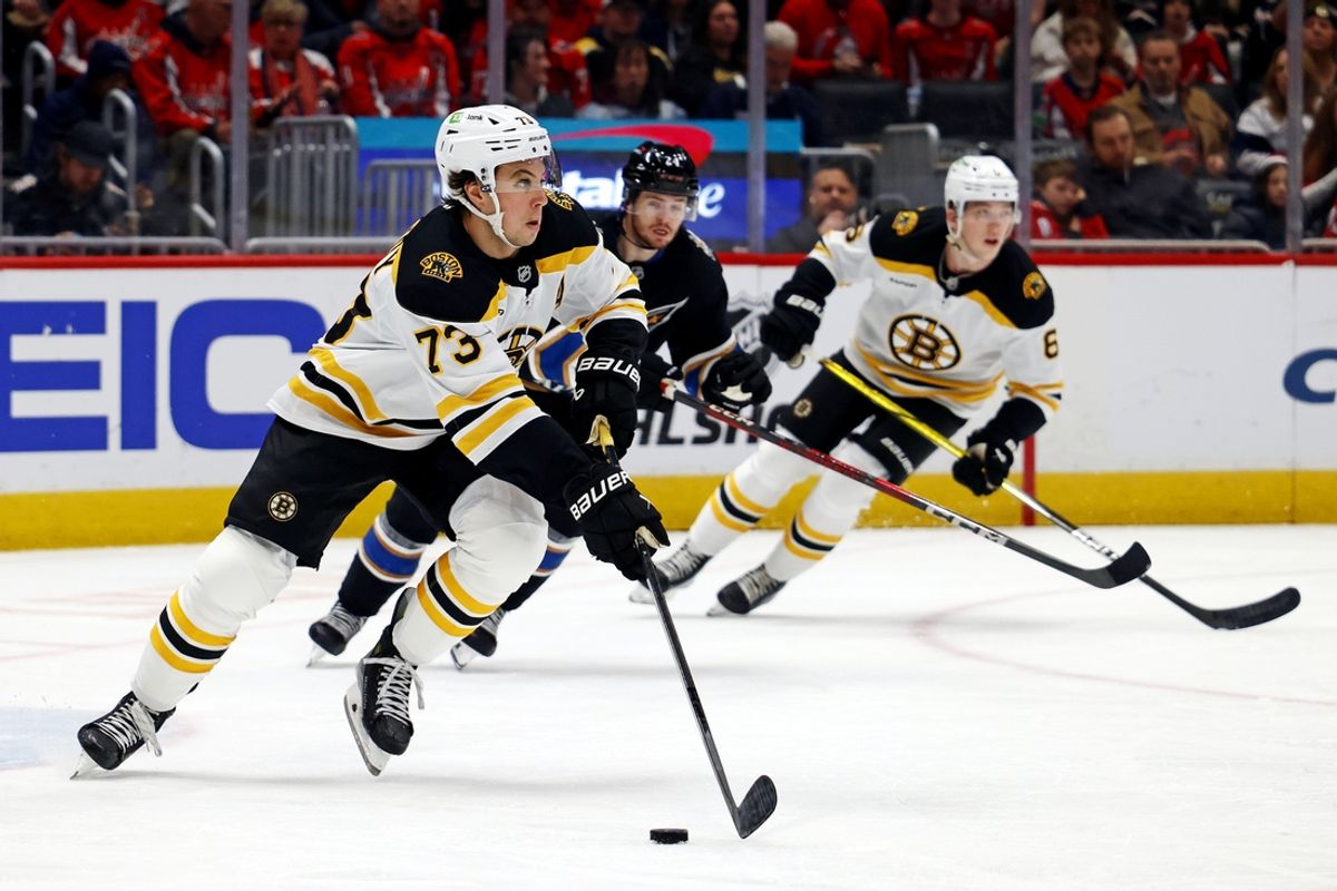 Dec 31, 2024; Washington, District of Columbia, USA; Boston Bruins defenseman Charlie McAvoy (73) skates with the puck against Washington Capitals center Connor McMichael (24) at Capital One Arena. Mandatory Credit: Peter Casey-Imagn Images