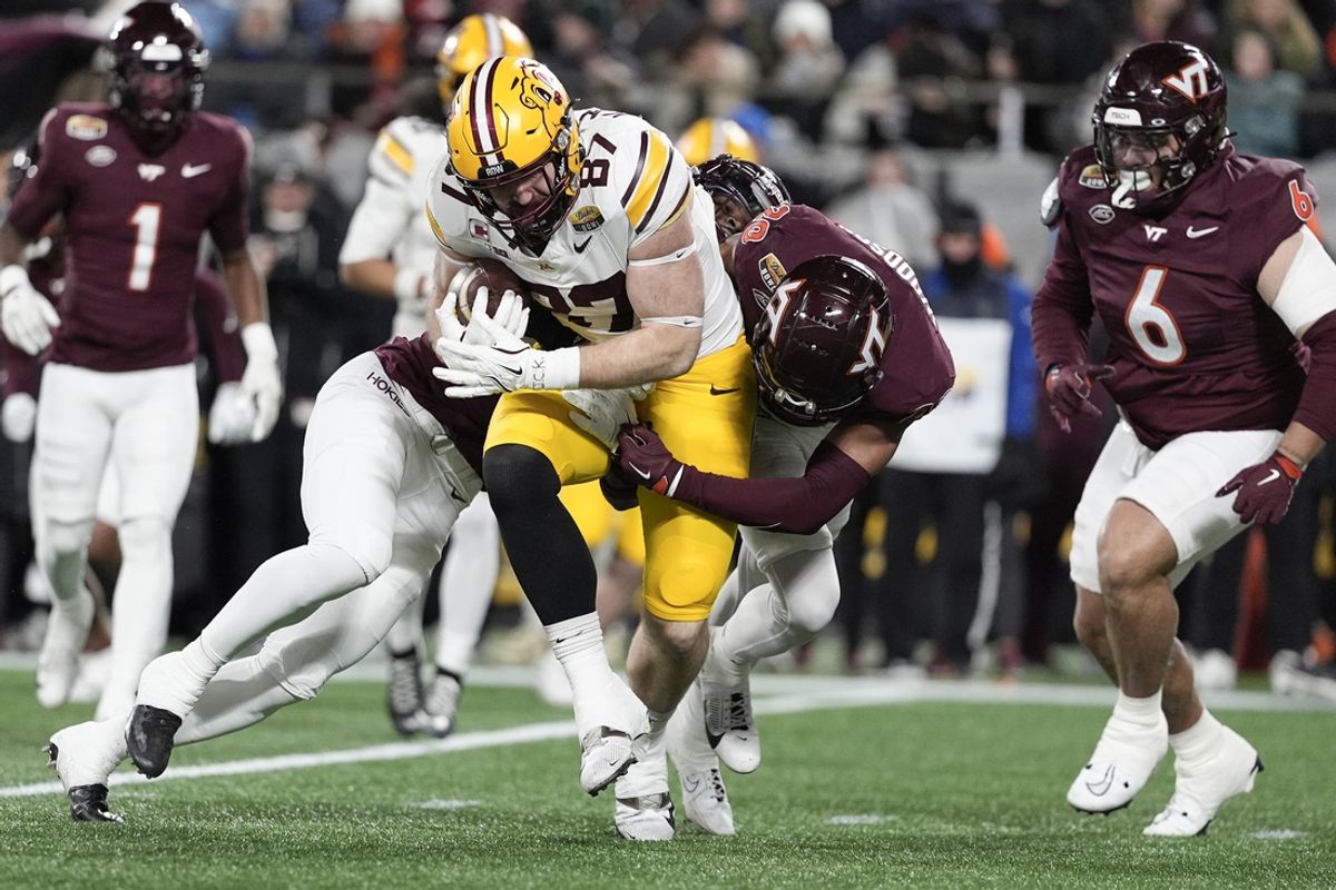 Jan 3, 2025; Charlotte, NC, USA; Minnesota Golden Gophers tight end Nick Kallerup (87) is tackled by Virginia Tech Hokies linebacker Caleb Woodson (20) during the first quarter of the Dukes’ Mayo Bowl at Bank of America Stadium. Mandatory Credit: Jim Dedmon-Imagn Images