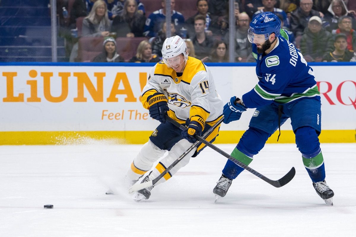 Jan 3, 2025; Vancouver, British Columbia, CAN; Nashville Predators forward Gustav Nyquist (14) battles with Vancouver Canucks forward Phillip Di Giuseppe (34) in the first period at Rogers Arena. Mandatory Credit: Bob Frid-Imagn Images