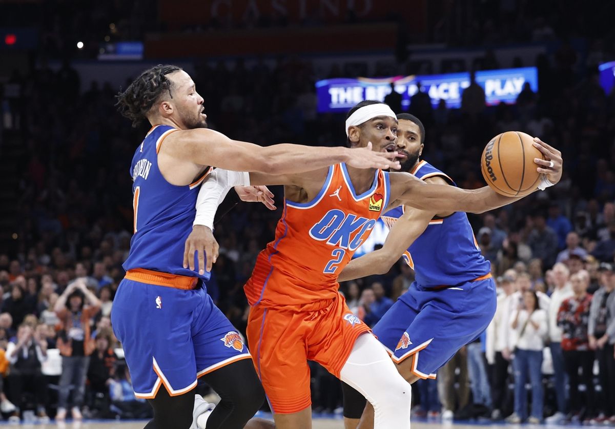 Jan 3, 2025; Oklahoma City, Oklahoma, USA; Oklahoma City Thunder guard Shai Gilgeous-Alexander (2) drives between New York Knicks guard Jalen Brunson (11) and forward Mikal Bridges (25) during the second half at Paycom Center. Mandatory Credit: Alonzo Adams-Imagn Images