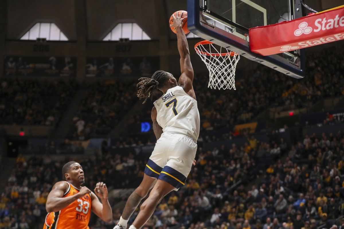 Jan 4, 2025; Morgantown, West Virginia, USA; West Virginia Mountaineers guard Javon Small (7) dunks the ball during the first half against the Oklahoma State Cowboys at WVU Coliseum. Mandatory Credit: Ben Queen-Imagn Images
