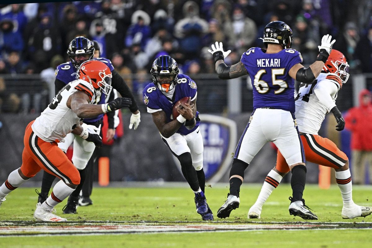 Jan 4, 2025; Baltimore, Maryland, USA; Baltimore Ravens quarterback Lamar Jackson (8) controls the ball as Cleveland Browns defensive end Myles Garrett (95) defends during the first quarter at M&T Bank Stadium. Mandatory Credit: Tommy Gilligan-Imagn Images
