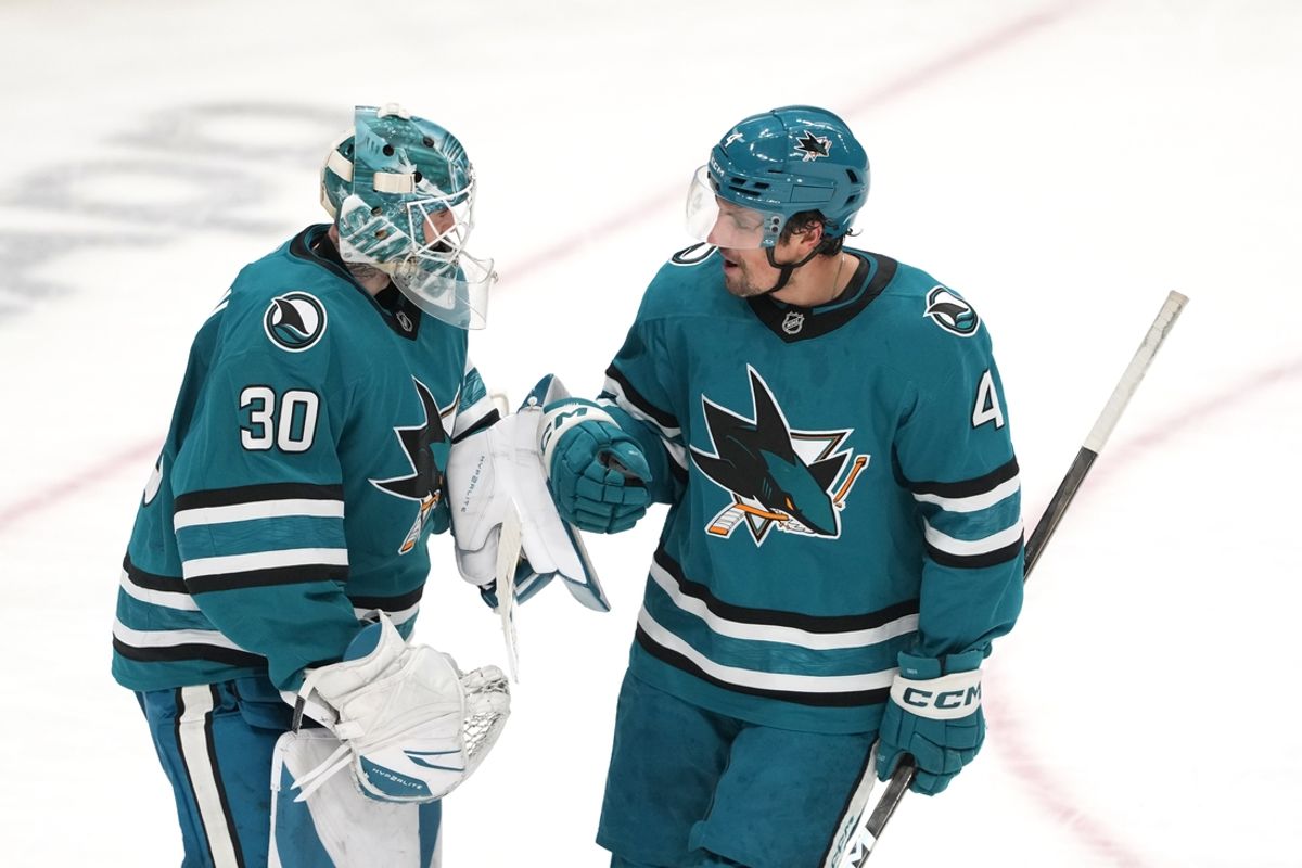 Jan 4, 2025; San Jose, California, USA; San Jose Sharks defenseman Cody Ceci (4) celebrates with goaltender Yaroslav Askarov (30) after scoring a goal against the New Jersey Devils during the third period at SAP Center at San Jose. Mandatory Credit: Darren Yamashita-Imagn Images
