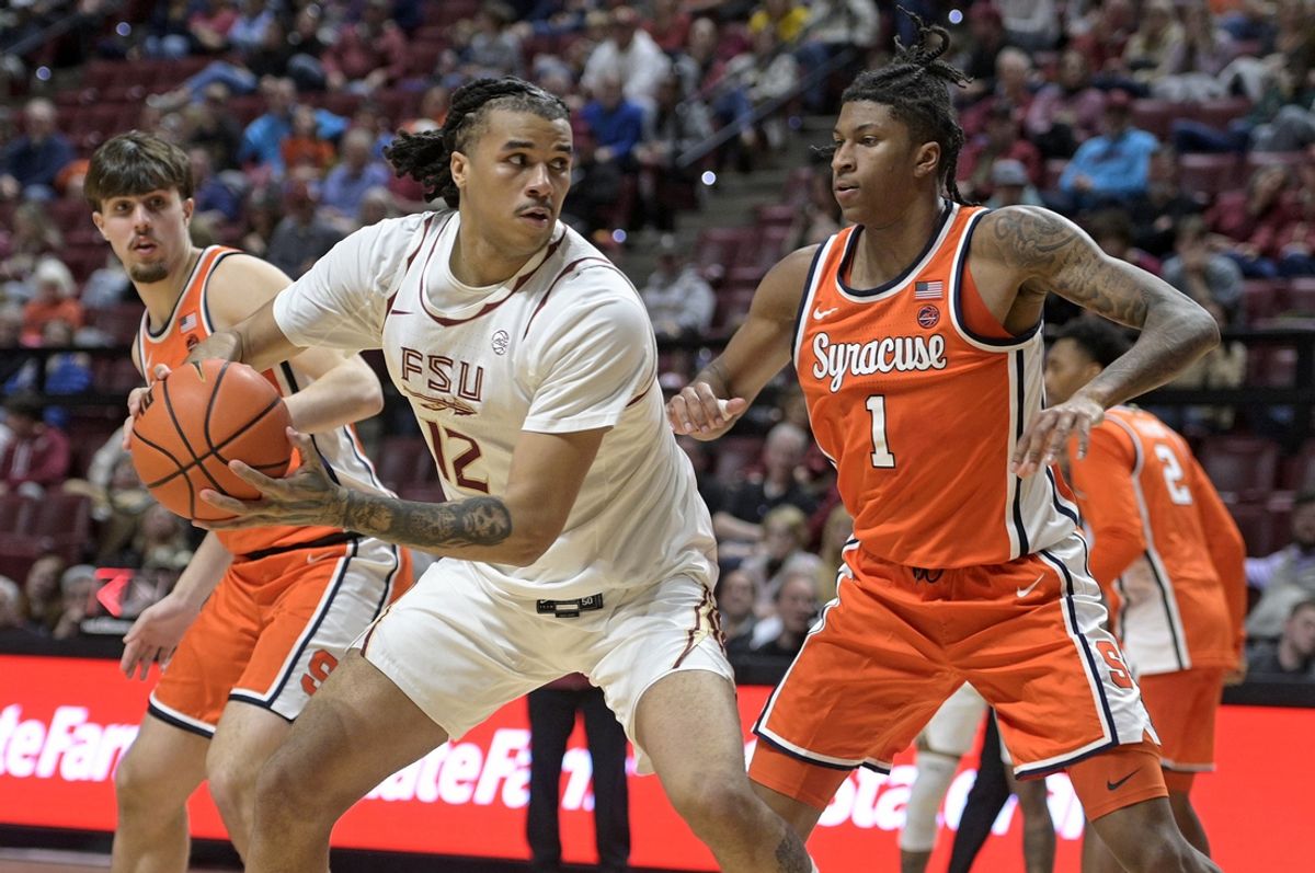 Jan 4, 2025; Tallahassee, Florida, USA; Florida State Seminoles forward Malique Ewin (12) controls the ball against Syracuse Orange forward Donnie Freeman (1) during the second half at Donald L. Tucker Center. Mandatory Credit: Melina Myers-Imagn Images