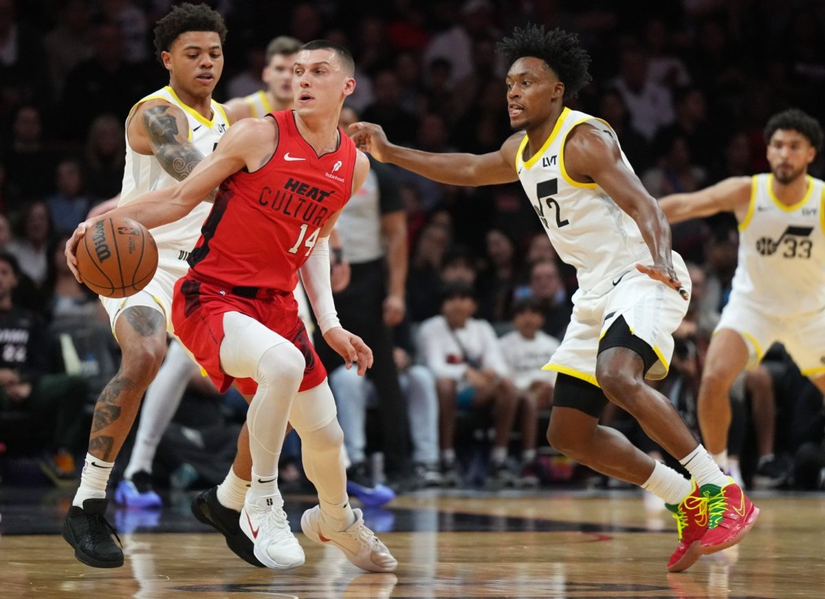 Jan 4, 2025; Miami, Florida, USA;  Miami Heat guard Tyler Herro (14) looks for space on the floor as Utah Jazz guard Collin Sexton (2) and guard Keyonte George (3) defend during the first half at Kaseya Center. Mandatory Credit: Jim Rassol-Imagn Images