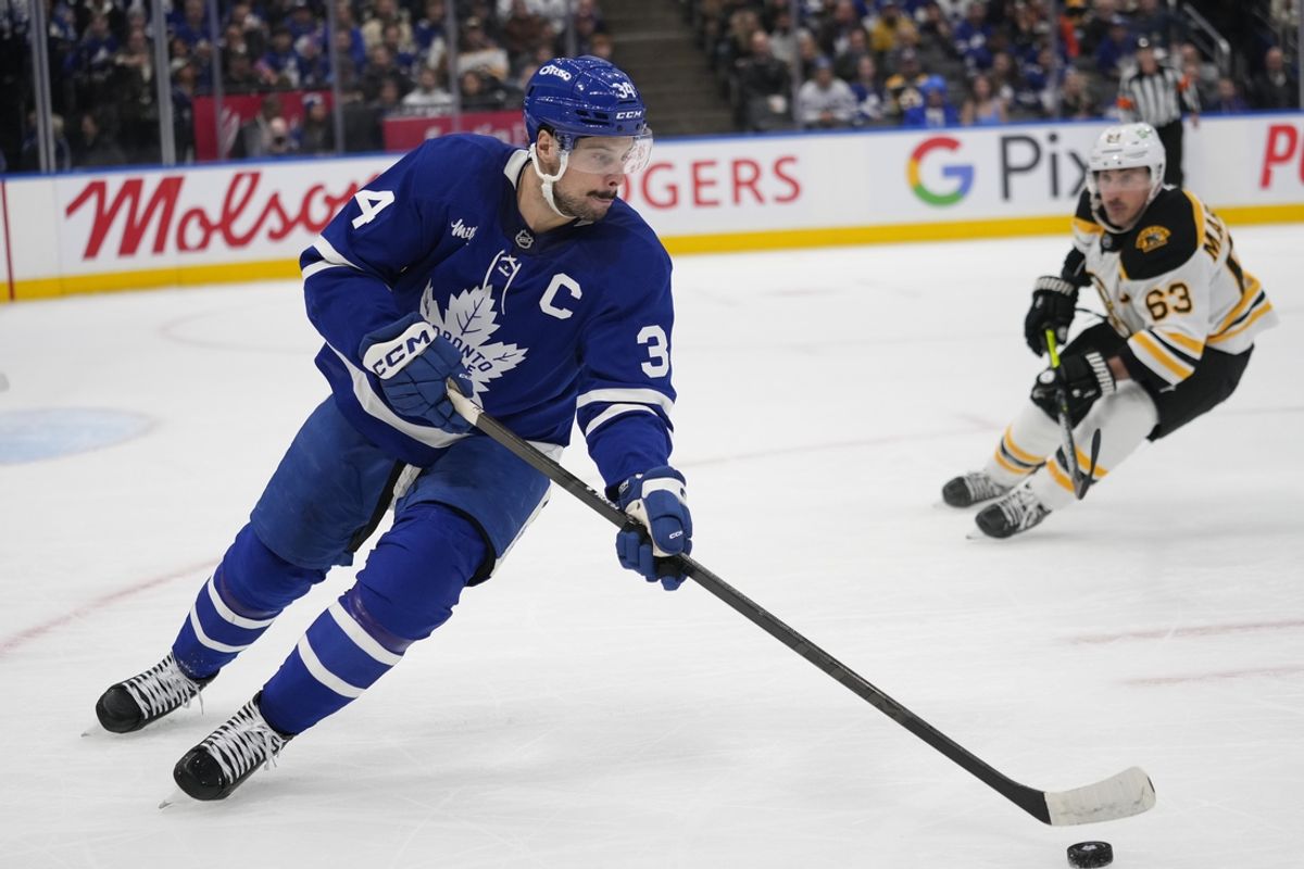 Jan 4, 2025; Toronto, Ontario, CAN; Toronto Maple Leafs forward Auston Matthews (34) carries the puck as Boston Bruins forward Brad Marchand (63) closes in during the second period at Scotiabank Arena. Mandatory Credit: John E. Sokolowski-Imagn Images