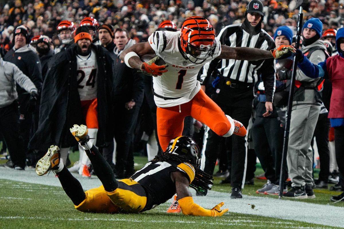 Bengals Ja'Marr Chase (1) leaps over a Steelers player during their game against the Steelers at Acrisure Stadium on Saturday January 4, 2025. The Bengals lead the game at halftime with a score of 13-7.