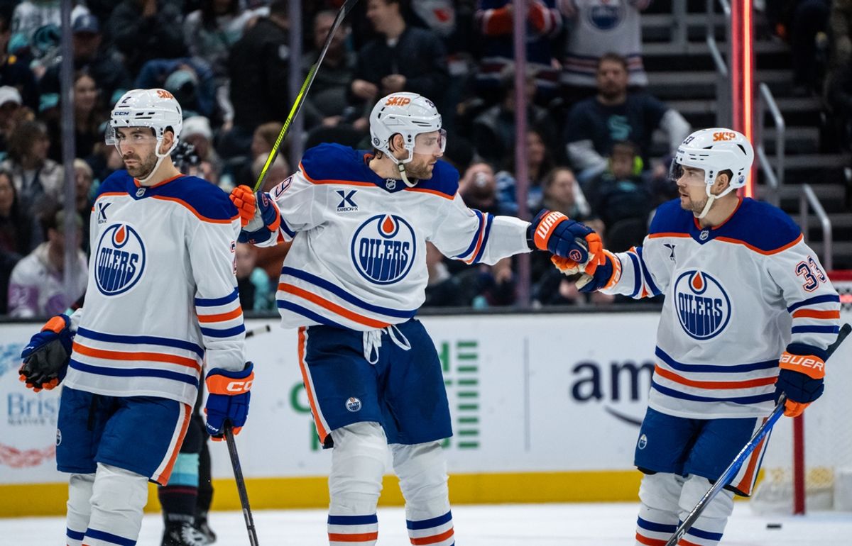 Jan 4, 2025; Seattle, Washington, USA;  Edmonton Oilers forward Leon Draisaitl (29), center, celebrates with forward Viktor Arvidsson (33) after scoiring an empty-net goal during the third period against the Seattle Kraken at Climate Pledge Arena. Mandatory Credit: Stephen Brashear-Imagn Images