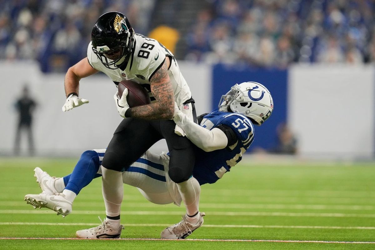 Indianapolis Colts linebacker Jaylon Carlies (57) works to bring down Jacksonville Jaguars tight end Luke Farrell (89) on Sunday, Jan. 5, 2025, during a game against the Jacksonville Jaguars at Lucas Oil Stadium in Indianapolis.