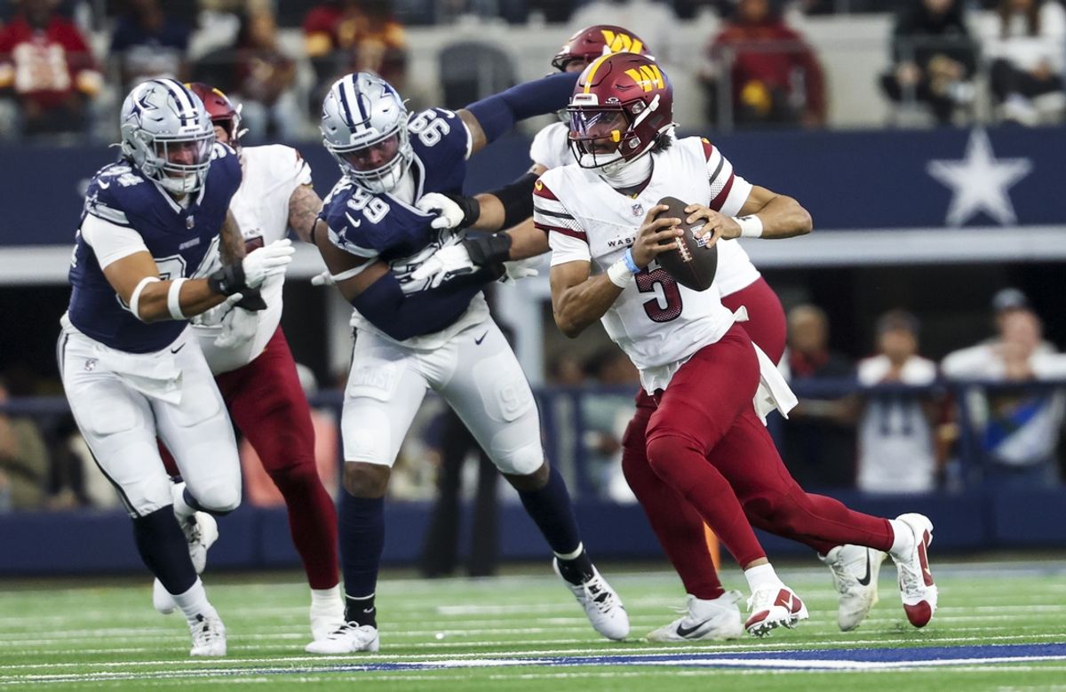 Jan 5, 2025; Arlington, Texas, USA;  Washington Commanders quarterback Jayden Daniels (5) runs with the ball past Dallas Cowboys defensive end Chauncey Golston (99) during the first half at AT&T Stadium. Mandatory Credit: Kevin Jairaj-Imagn Images