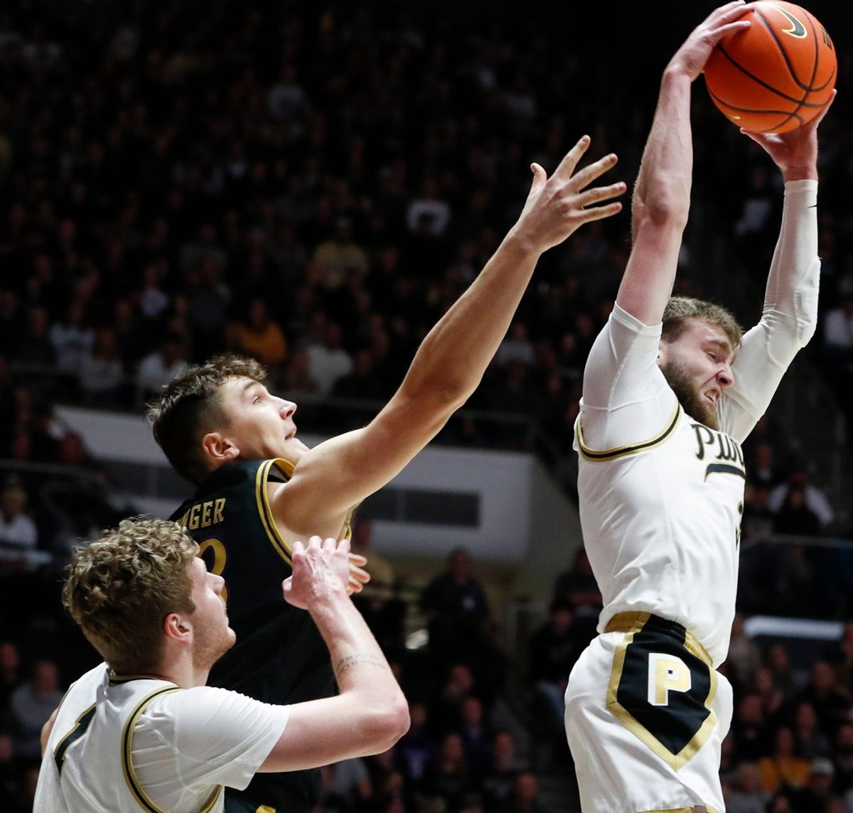 Purdue Boilermakers guard Braden Smith (3) grabs a rebound over Purdue Boilermakers forward Caleb Furst (1) and Northwestern Wildcats forward Luke Hunger (33) Sunday, Jan. 5, 2025, during the NCAA men’s basketball game at Mackey Arena in West Lafayette, Ind.