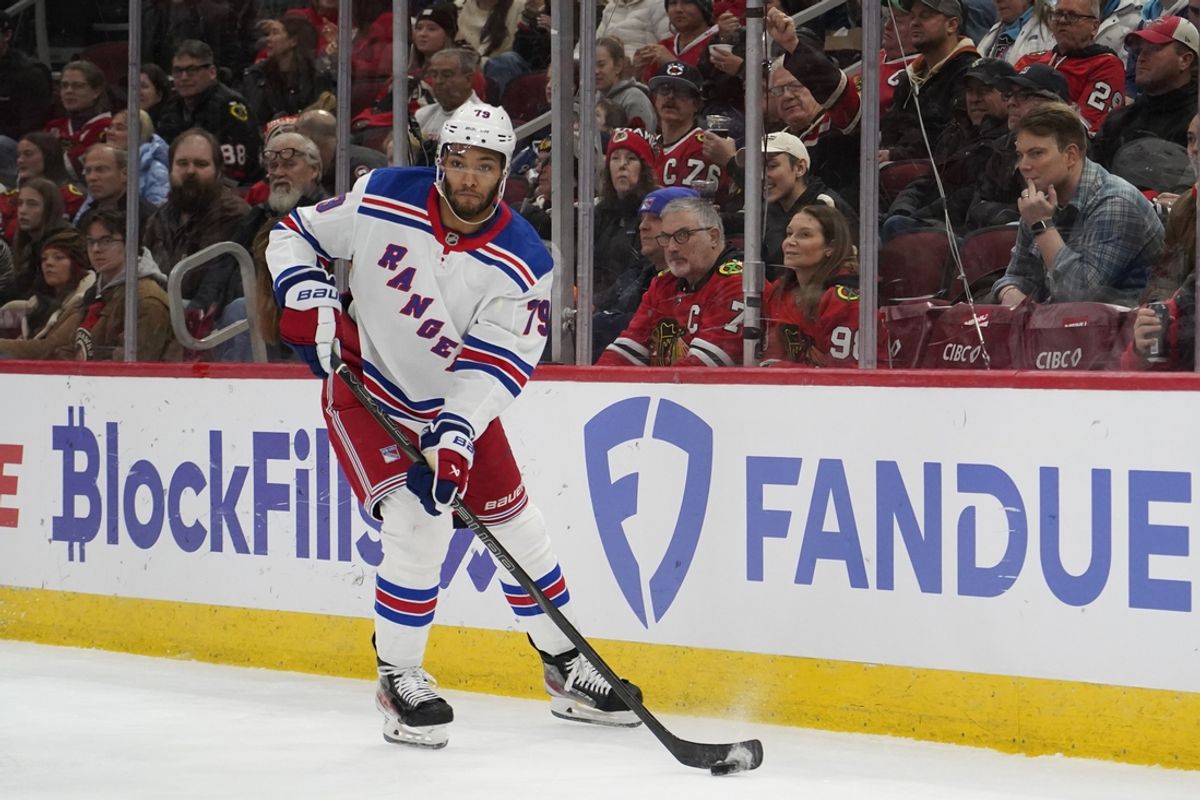 Jan 5, 2025; Chicago, Illinois, USA; New York Rangers defenseman K'Andre Miller (79) clears the puck from the defensive zone against the Chicago Blackhawks during the second period at United Center. Mandatory Credit: David Banks-Imagn Images