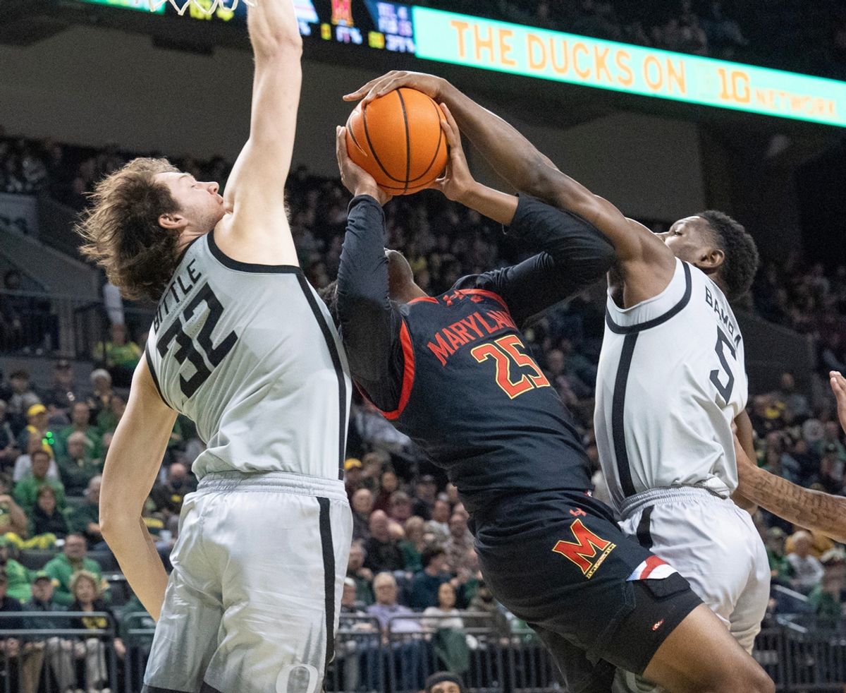 Oregon’s Nate Bittle, left, and TJ Bamba, right, force a turnover against Maryland’s Derik Queen during the first half at Matthew Knight Arena.