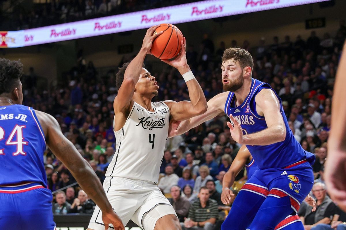 Jan 5, 2025; Orlando, Florida, USA; UCF Knights guard Keyshawn Hall (4) goes to the basket against Kansas Jayhawks center Hunter Dickinson (1) during the first half at Addition Financial Arena. Mandatory Credit: Mike Watters-Imagn Images