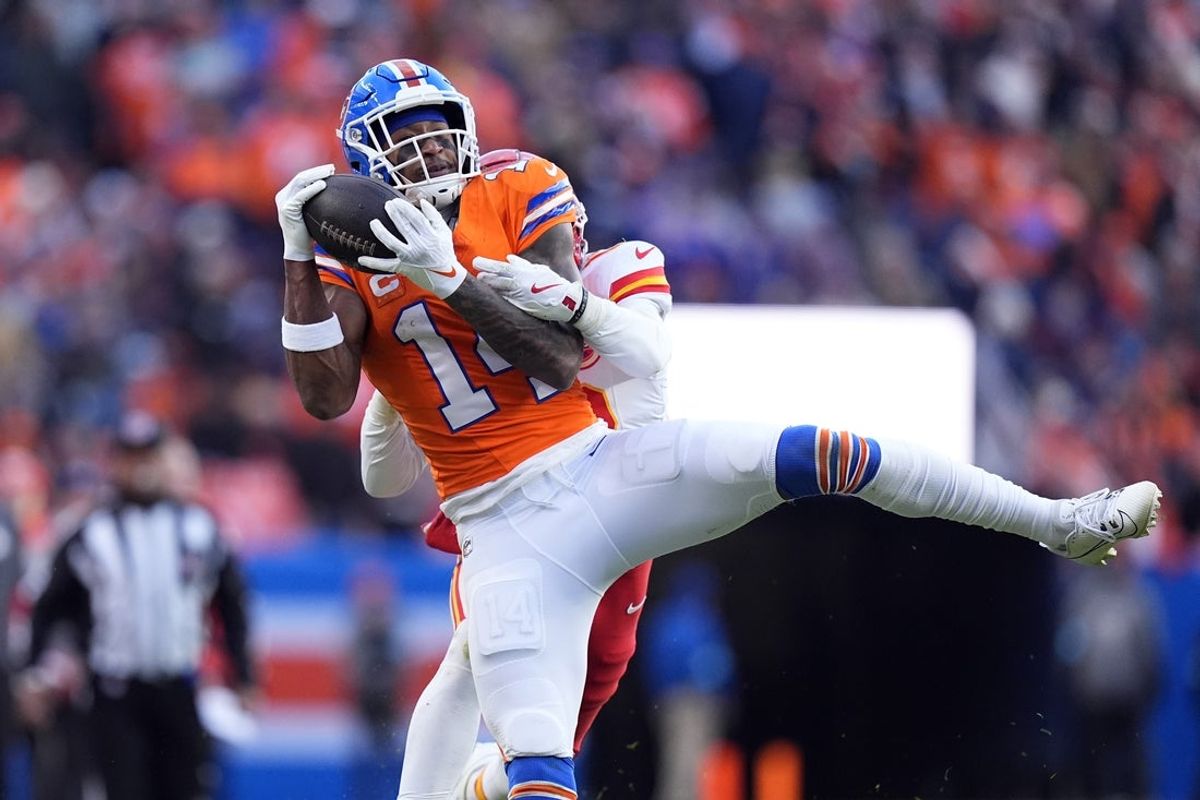 Jan 5, 2025; Denver, Colorado, USA; Denver Broncos wide receiver Courtland Sutton (14) pulls in a reception past Kansas City Chiefs safety Nazeeh Johnson (13) in the second quarter at Empower Field at Mile High. Mandatory Credit: Ron Chenoy-Imagn Images