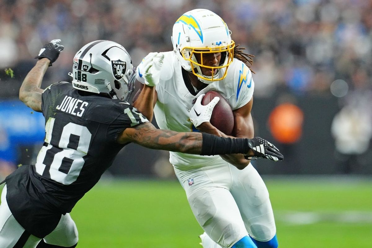 Jan 5, 2025; Paradise, Nevada, USA; Las Vegas Raiders cornerback Jack Jones (18) looks to tackle Los Angeles Chargers wide receiver Quentin Johnston (1) during the second quarter at Allegiant Stadium. Mandatory Credit: Stephen R. Sylvanie-Imagn Images