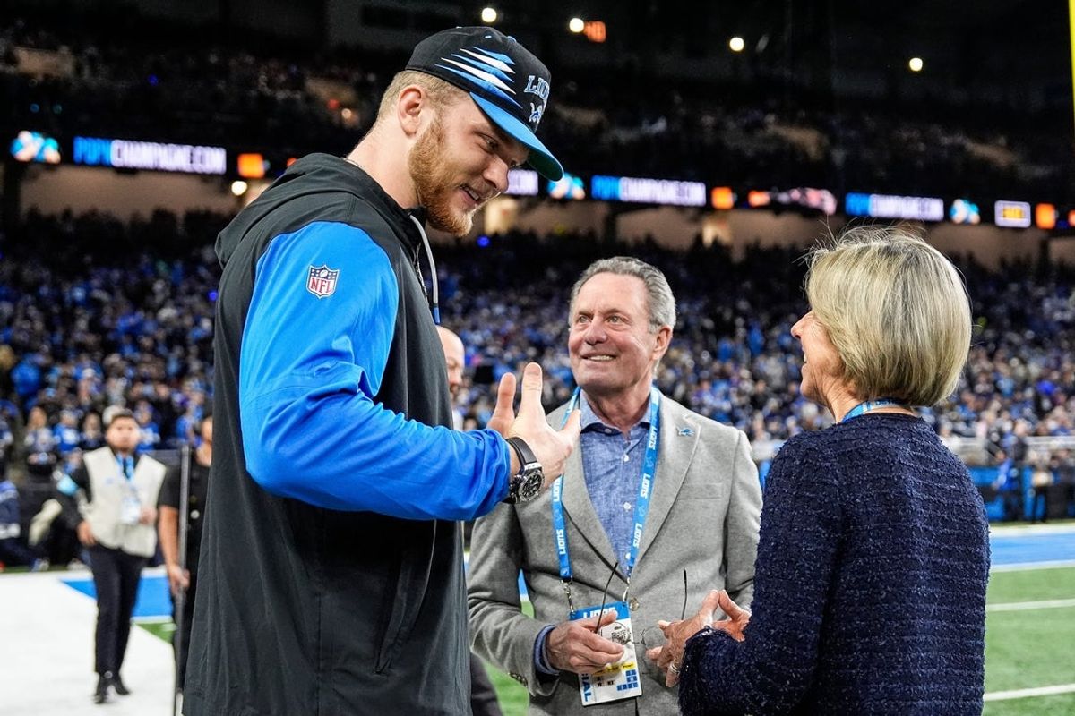 Detroit Lions defensive end Aidan Hutchinson (97) talks to principal owner and chair Sheila Ford Hamp, right, and her husband Steve Hamp before the game between Detroit Lions and Minnesota Vikings at Ford Field in Detroit on Sunday, Jan. 5, 2025.