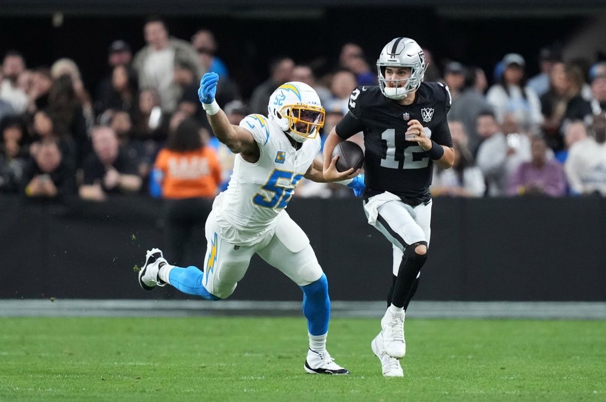 Jan 5, 2025; Paradise, Nevada, USA; Las Vegas Raiders quarterback Aidan O'Connell (12) carries the ball against Los Angeles Chargers linebacker Khalil Mack (52) in the second half at Allegiant Stadium. Mandatory Credit: Kirby Lee-Imagn Images