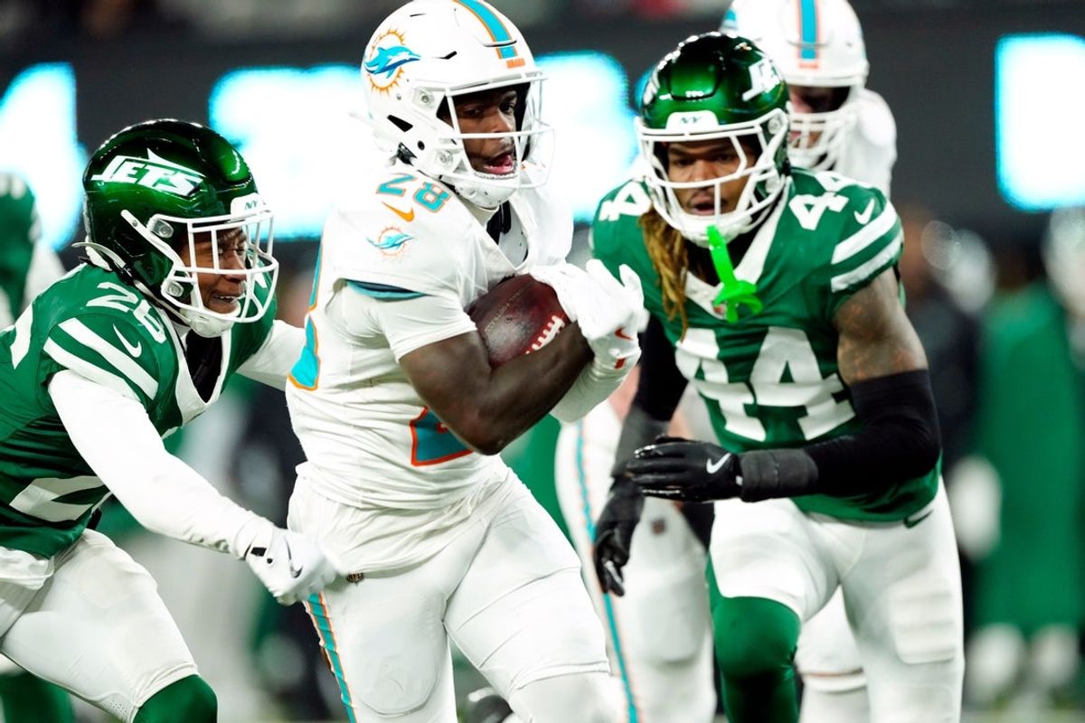 Miami Dolphins running back De'Von Achane (28) scores a touchdown after running past New York Jets cornerback Brandin Echols (26) and New York Jets linebacker Jamien Sherwood (44) in the fourth quarter, Sunday January 5, 2025, in East Rutherford.