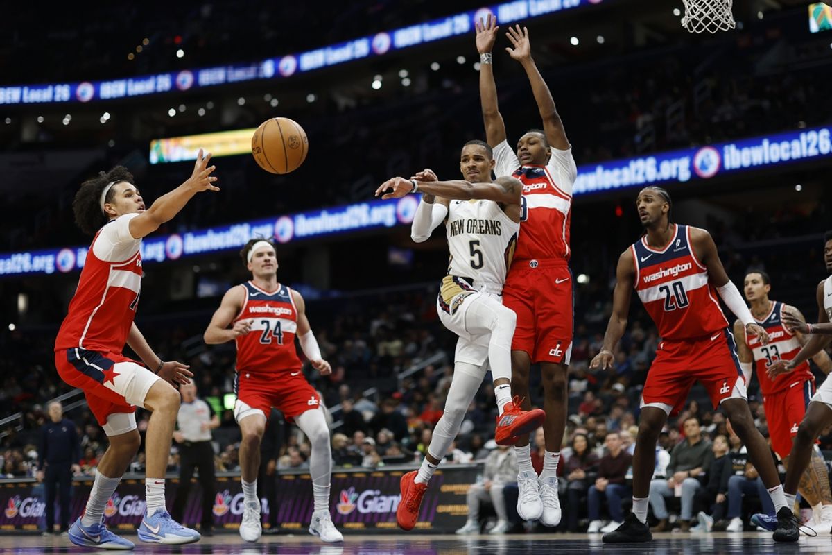 Jan 5, 2025; Washington, District of Columbia, USA; New Orleans Pelicans guard Dejounte Murray (5) passes the ball as Washington Wizards forward Kyshawn George (18) and Wizards guard Bub Carrington (8) defend in the fourth quarter at Capital One Arena. Mandatory Credit: Geoff Burke-Imagn Images
