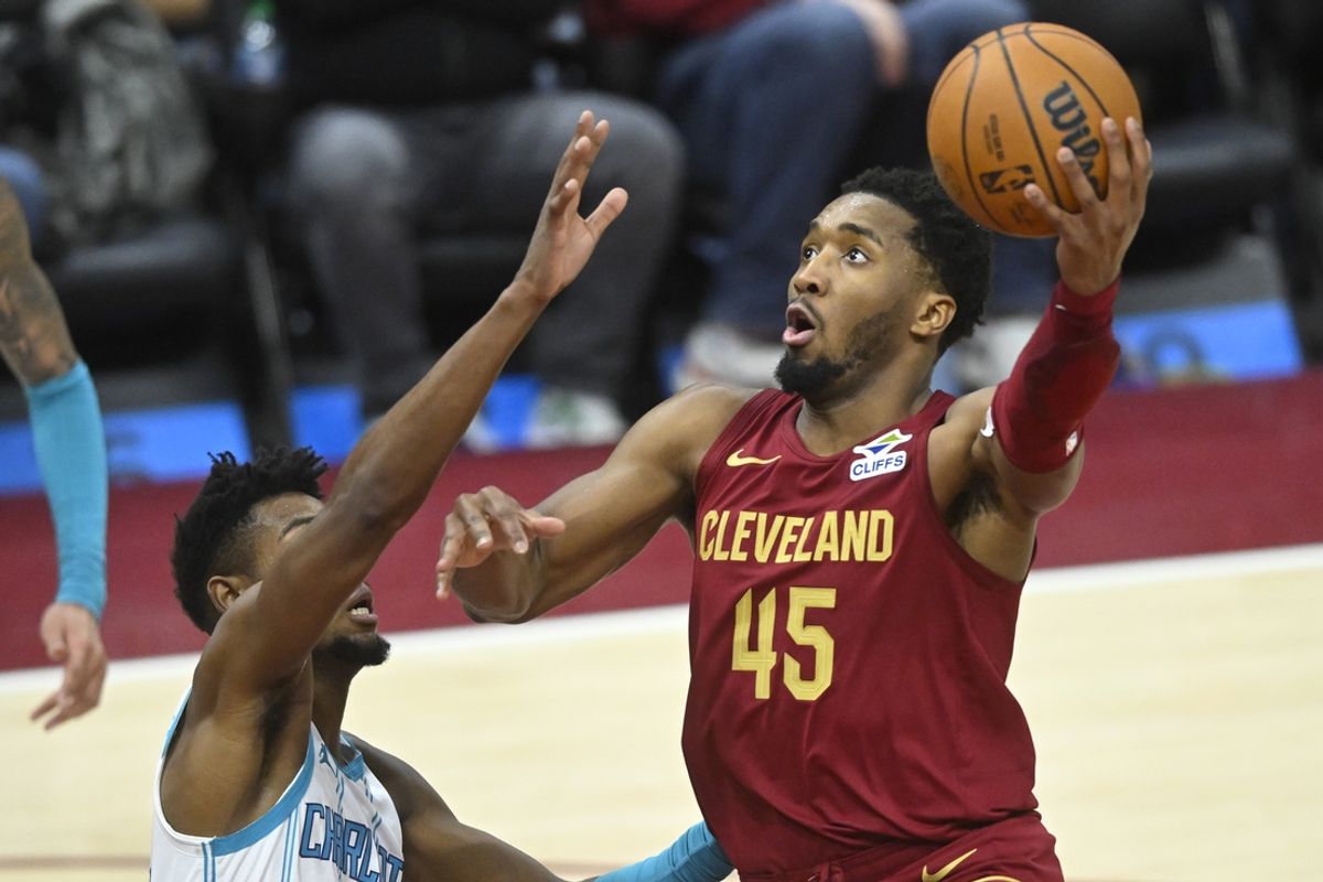 Jan 5, 2025; Cleveland, Ohio, USA; Cleveland Cavaliers guard Donovan Mitchell (45) shoots beside Charlotte Hornets forward Brandon Miller (24) in the fourth quarter at Rocket Mortgage FieldHouse. Mandatory Credit: David Richard-Imagn Images