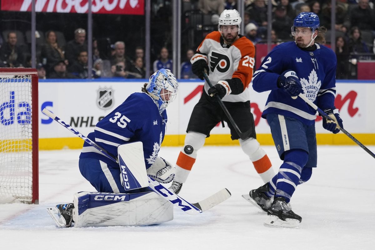 Jan 5, 2025; Toronto, Ontario, CAN; Toronto Maple Leafs goaltender Dennis Hildeby (35) makes a save as defenceman Simon Benoit (2) and Philadelphia Flyers forward Ryan Poehling (25) look on during the second period at Scotiabank Arena. Mandatory Credit: John E. Sokolowski-Imagn Images