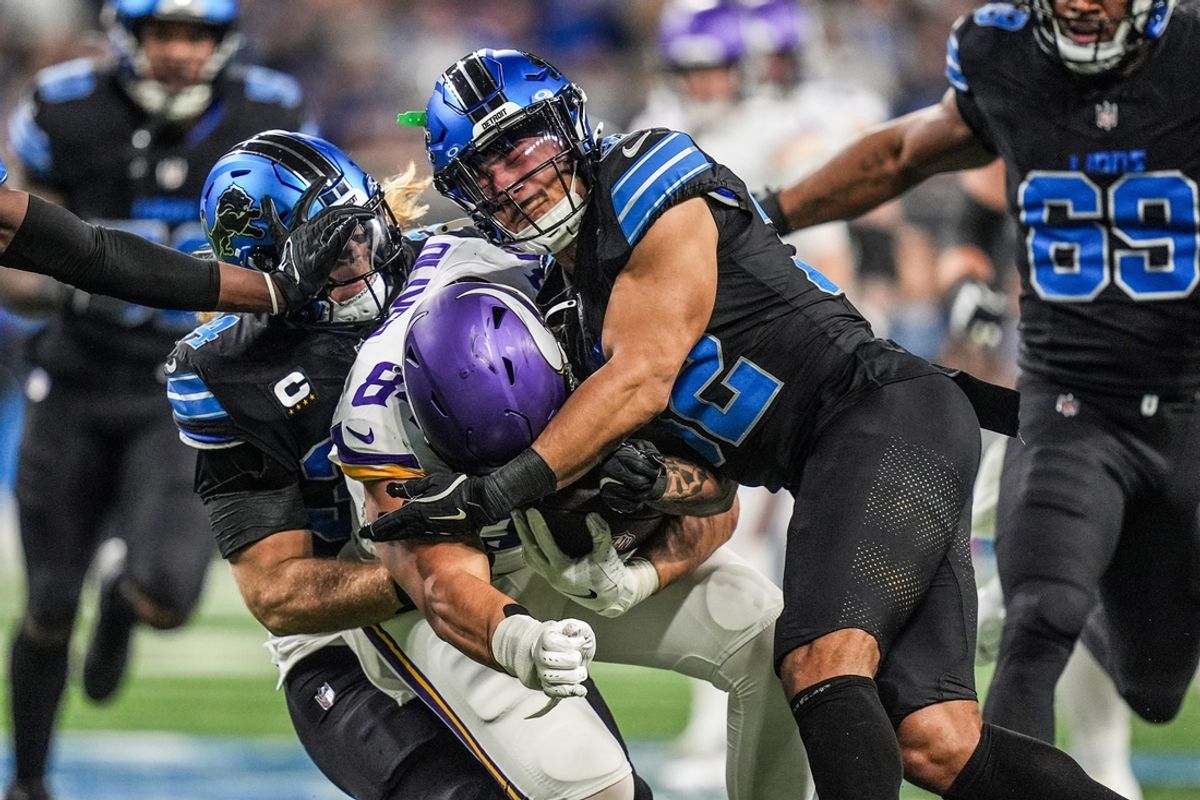 Minnesota Vikings tight end Josh Oliver (84) is tackled by Detroit Lions linebacker Alex Anzalone (34) and safety Brian Branch (32) during the first half of the NFL game at Ford Field in Detroit on Sunday, Jan. 5, 2025.