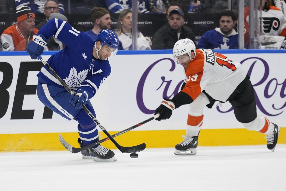 Jan 5, 2025; Toronto, Ontario, CAN; Toronto Maple Leafs forward John Tavares (91) tries to carry the puck past Philadelphia Flyers forward Matvei Michkov (39) during the third period at Scotiabank Arena. Mandatory Credit: John E. Sokolowski-Imagn Images