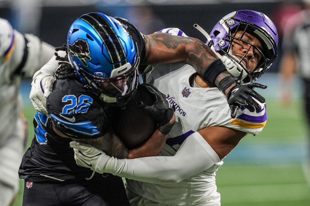 Detroit Lions running back Jahmyr Gibbs (26) fights the tackle by Minnesota Vikings safety Camryn Bynum (24) during the second half at Ford Field in Detroit on Sunday, Jan. 5, 2025.