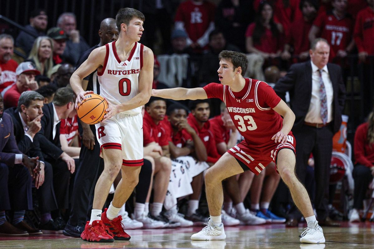 Jan 6, 2025; Piscataway, New Jersey, USA; Rutgers Scarlet Knights guard Jordan Derkack (0) looks to pass as Wisconsin Badgers guard Jack Janicki (33) defends during the first half at Jersey Mike's Arena. Mandatory Credit: Vincent Carchietta-Imagn Images