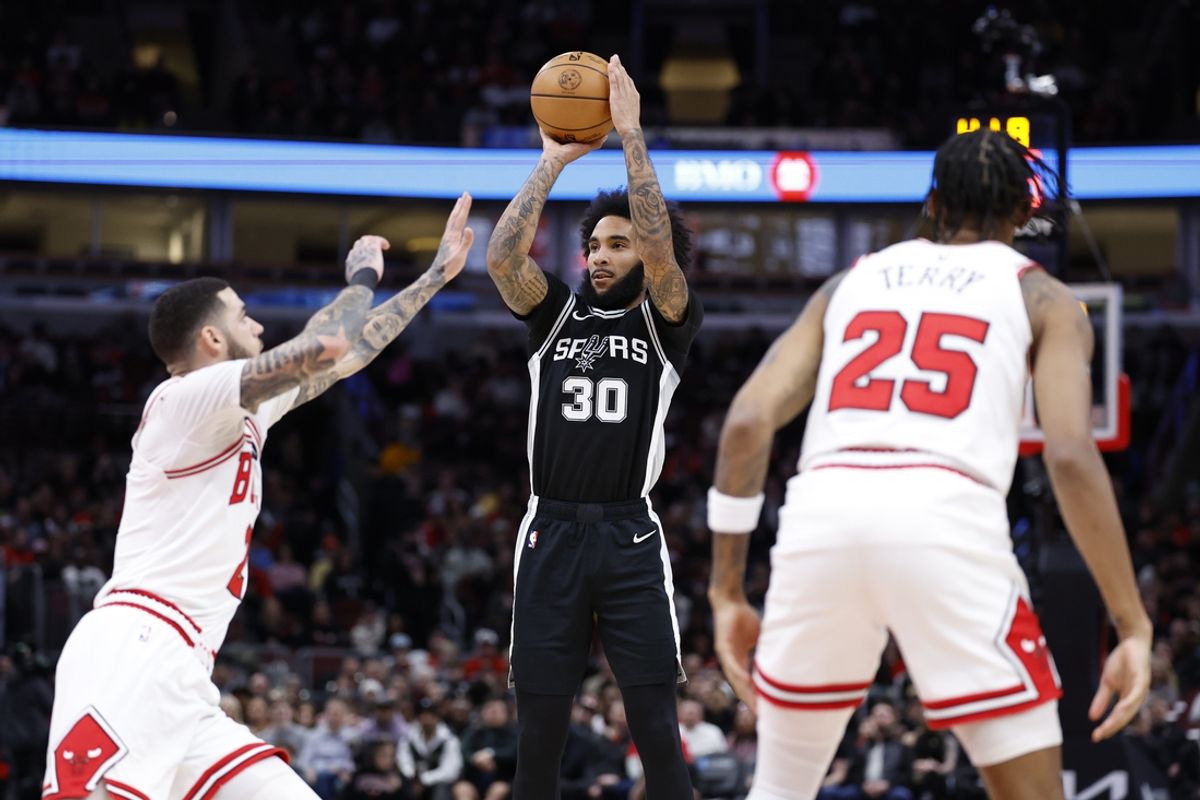 Jan 6, 2025; Chicago, Illinois, USA; San Antonio Spurs forward Julian Champagnie (30) shoots against Chicago Bulls guard Lonzo Ball (2)  during the first half at United Center. Mandatory Credit: Kamil Krzaczynski-Imagn Images