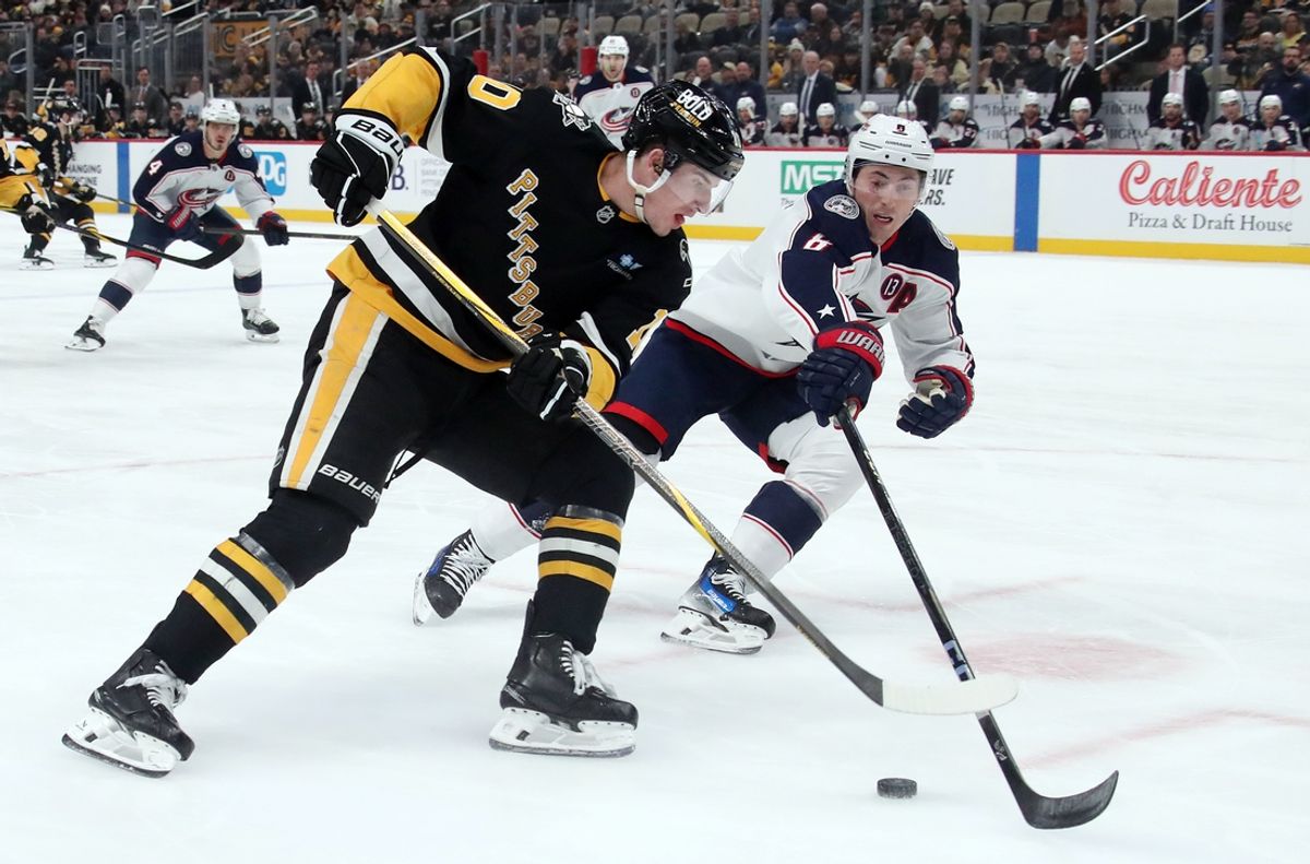 Jan 7, 2025; Pittsburgh, Pennsylvania, USA; Pittsburgh Penguins left wing Drew O'Connor (10) skates with the puck against Columbus Blue Jackets defenseman Zach Werenski (8) during the first period at PPG Paints Arena. Mandatory Credit: Charles LeClaire-Imagn Images
