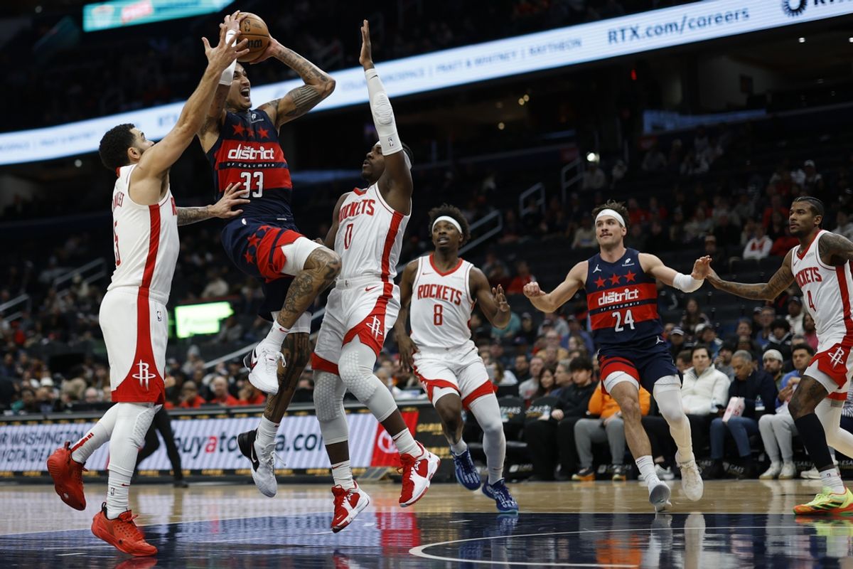 Jan 7, 2025; Washington, District of Columbia, USA; Washington Wizards forward Kyle Kuzma (33) drives to the basket as Houston Rockets guard Fred VanVleet (5) and Rockets guard Aaron Holiday (0) defend during the first quarter at Capital One Arena. Mandatory Credit: Geoff Burke-Imagn Images